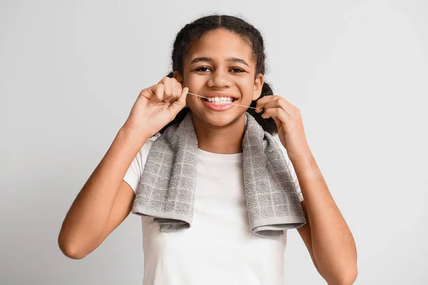 Afroamerikanisches Teenagermädchen Mit Zahnseide Auf Hellem Hintergrund — Stockfoto