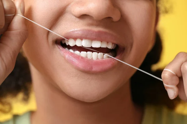 Niña Adolescente Afroamericana Usando Hilo Dental Sobre Fondo Amarillo Primer —  Fotos de Stock
