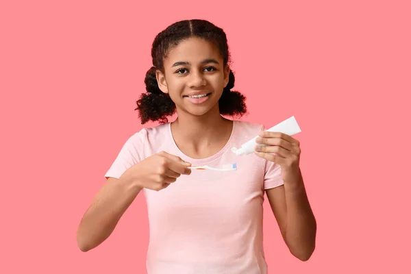 Menina Adolescente Afro Americana Aplicando Pasta Dente Escova Fundo Rosa — Fotografia de Stock