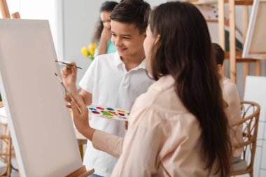 Sanat yüksek lisansı sırasında sevimli bir çocuk ve öğretmen.