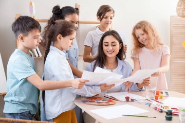 Sanat yüksek lisansı sırasında öğretmenlerine resimlerini gösteren sevimli çocuklar.