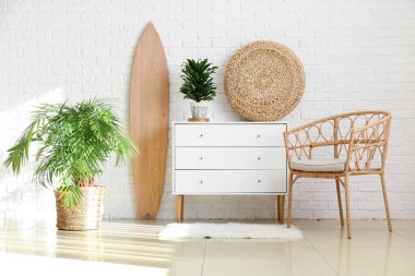 Ahşap sörf tahtası, klozeti ve koltuğu olan ışık odasının içi.