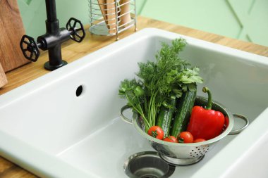 Seramik lavaboda taze sebzeli Colander, yakın plan.