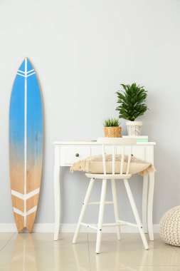 Işık duvarının yanında ev bitkileri ve sörf tahtaları olan bir işyeri