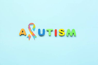 Kelime AUTISM mavi arkaplanda kağıt farkındalığı kurdelesi