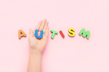 Pembe arka planda kelime AUTISM çocuk