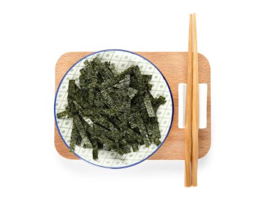 Beyaz arka planda doğranmış yosun çarşafları ve çubuklarla dolu bir tabak.