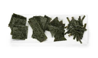 Beyaz arka planda lezzetli yosun örtüleri olan bir tabak.