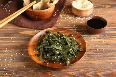 Tahta zemin üzerinde susam olan doğranmış yosun tabakası.