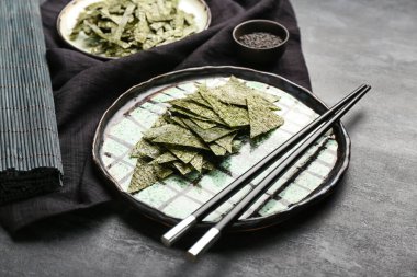 Siyah arka planda lezzetli deniz yosunları tabakları