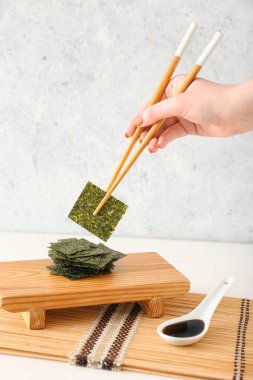 Masada lezzetli yosun çarşafları yiyen bir kadın.