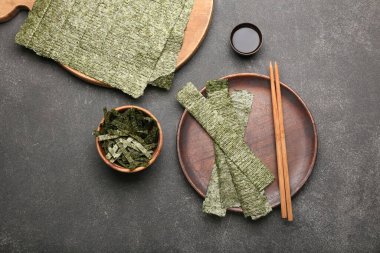 Lezzetli bir tabak yosun ve siyah arka planda soya soslu bir kase.