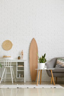 Tahta sörf tahtası ve işyeriyle aydınlık oturma odasının içinde.