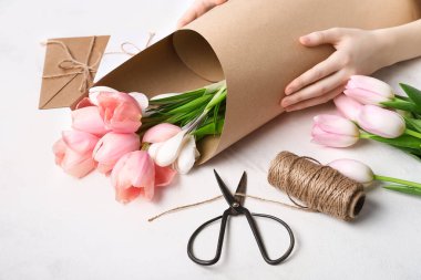 Kadın arka planda güzel bir buket yapıyor.