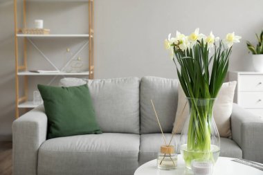 Nergisli vazo ve sazlık ayırıcı açık oturma odasındaki masada.