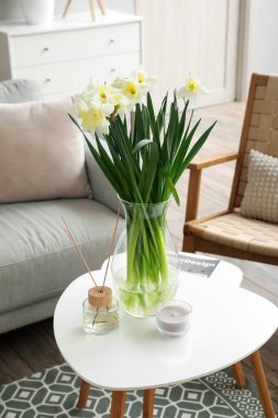 Nergisli vazo ve sazlık ayırıcı açık oturma odasındaki masada.