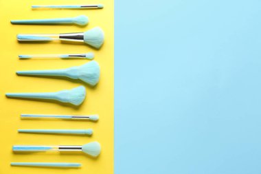 Mavi ve sarı arkaplanda makyaj fırçaları