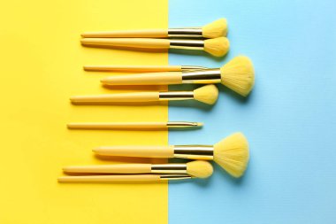 Mavi ve sarı arkaplanda makyaj fırçaları