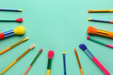 Renk arkaplanında makyaj fırçaları olan kompozisyon