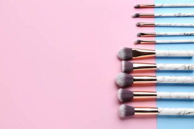 Mavi ve pembe arkaplanda makyaj fırçaları