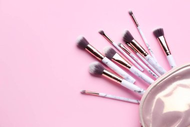 Pembe arka planda makyaj fırçası seti