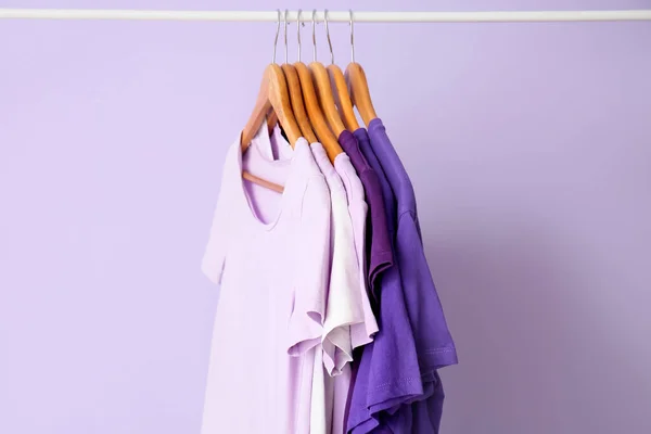 Support Avec Shirts Dans Les Tons Violets Sur Fond Lilas — Photo