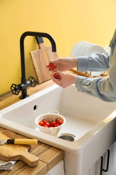 女人在厨房的水槽上洗樱桃西红柿 — 图库照片