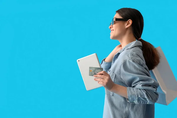 Junge Frau Mit Tablet Computer Kreditkarte Und Einkaufstasche Auf Farbigem — Stockfoto