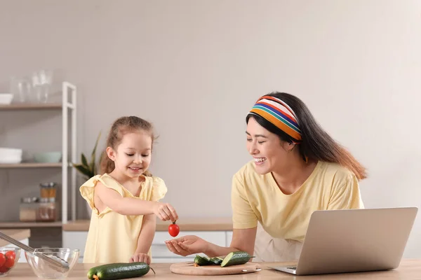 Busy Mother Cooking Her Little Daughter While Working Home — Stock Photo, Image