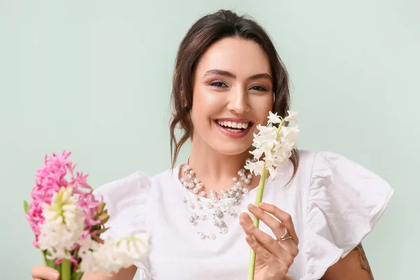 Yeşil Arka Planda Sümbül Çiçekleri Olan Güzel Genç Bir Kadın — Stok fotoğraf