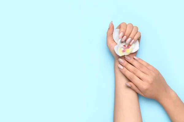 Mujer Con Hermosa Manicura Sosteniendo Flor Orquídea Sobre Fondo Azul — Foto de Stock