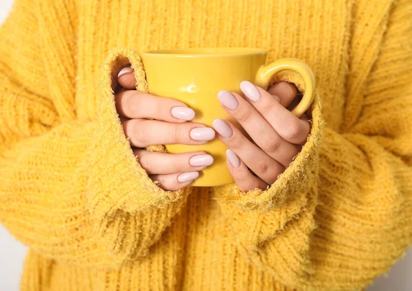 Modaya uygun manikür fincanı olan genç bir kadın, yakın plan.