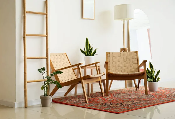 Eski halı, koltuk ve merdiveni olan rahat bir oturma odası.