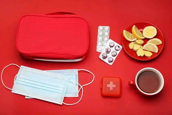 レモンと生姜のスライスのカップ 喉の痛みのための錠剤 赤い背景の袋と医療用マスク — ストック写真