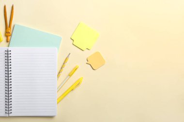 Sarı arkaplanda boş defter ve kırtasiye malzemesi