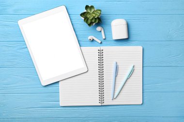 Boş defter, aygıtlar ve mavi ahşap arka plan kırtasiyesi