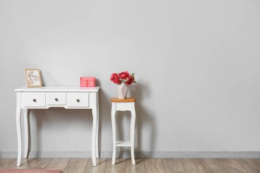 Vazoda çiçekli tablolar, resim ve küp takvimi ışık duvarının yanında