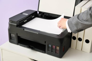 Renk duvarı yakınındaki belgeyi kopyalayan iş kadını, kapat