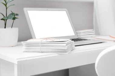 Günümüz dizüstü bilgisayarının yanında yığınla mektup var.