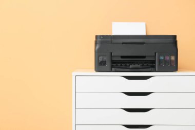 Renk duvarının yanındaki çekmecelerin üstündeki modern yazıcı