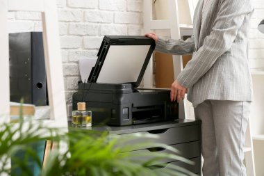 Beyaz tuğla duvarın yakınındaki belgeleri tarayan iş kadını