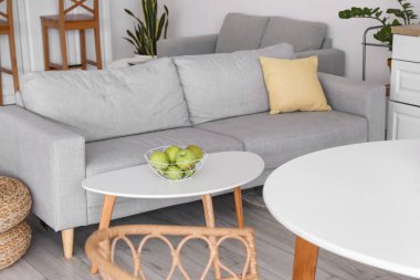 Rahat bir kanepe ve bir sepet taze elmayla dolu bir masa.