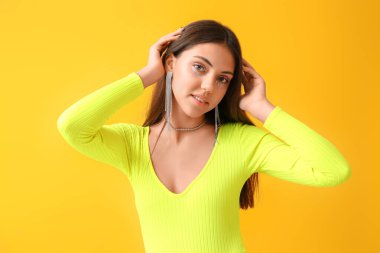 Sarı arka planda yaratıcı makyajlı kadın portresi