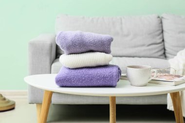 Odadaki masada örülmüş süveter ve bardak yığını.