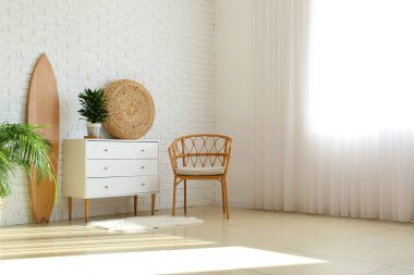 Ahşap sörf tahtası, klozeti ve koltuğu olan ışık odasının içi.