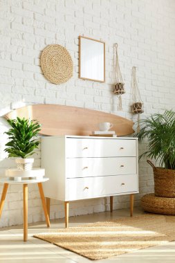 Ahşap sörf tahtası, klozet ve ev bitkileriyle aydınlatma odasının içinde.