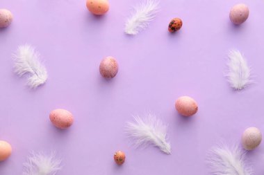 Paskalya yumurtası boyalı kompozisyon ve leylak arka planda tüyler