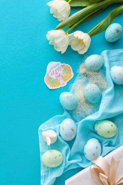 Renkli arkaplanda yumurta ve lale çiçekleri olan güzel Paskalya kompozisyonu