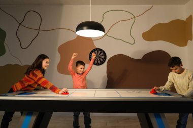 Küçük çocuklar içeride hokey oynuyorlar.