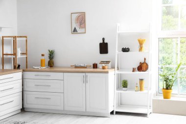 İçinde raf ünitesi olan aydınlık modern mutfak.